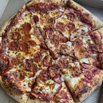 Davidos - 18" pepperoni pizza - An 18-inch pepperoni pizza with a golden-brown crust, topped with melted cheese and evenly distributed pepperoni slices, placed inside a cardboard pizza box. The pizza appears freshly baked with some slightly charred edges. - Pizza Near Me - Rio Rancho, New Mexico