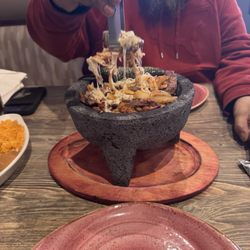 Molcajete steak, grilled chicken, shrimp, rice and beans in the side.