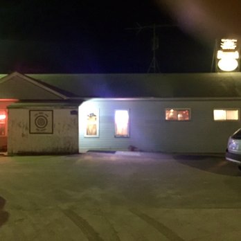 The Bent Rim - two cars parked in front of a building at night - Bars Near Me - Cascade, Iowa