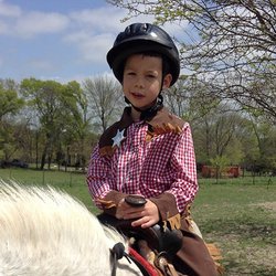 Anna Acres - Young cowboy on a pony ride.