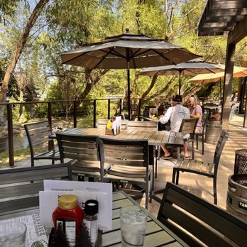 Tamarack Alehouse & Grill - Outdoor patio under the shade trees and access to the creek below - Burgers Near Me - Lakeside, Montana