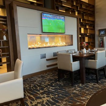 Panorama on 7 - a dining room with a television and fireplace - Cocktail Bars Near Me - Buffalo, New York
