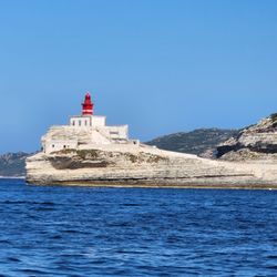 Nautic Aventures - Red Lighthouse on Limestone Cliffs