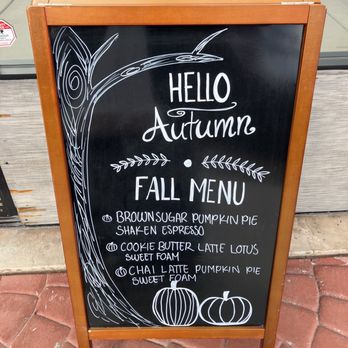 El Cafezito - A black chalkboard sign with a wooden frame features a fall menu for a café, listing pumpkin-flavored drinks and decorated with pumpkin illustrations and autumn-themed drawings. - Creperies Near Me - Phoenix, Arizona