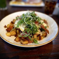 Double bacon breakfast hash, potatoes, eggs, cheese, crumbled bacon, two bacon slices, carmelized onions, mixed greens, cream sauce.