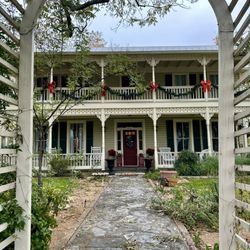 Carriage House - Street entry with white picket fence and archway