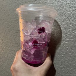 a hand holding a plastic cup filled with ice