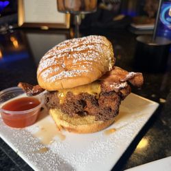 Signature sweet heat stack. Fried to perfection chicken breast tossed in honey hot sauce, egg, cheese, and bacon on a brioche bun.