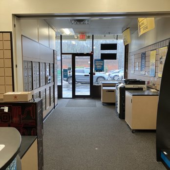 The UPS Store - Interior view of a postal store entrance with mailboxes on the left, a door with glass panels, and parking lot outside. - Shipping Centers Near Me - Acton, Massachusetts