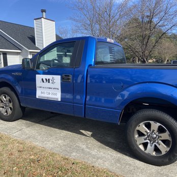 AMC Lawn and Landcsaping - a blue truck parked in front of a house - Lawn Services Near Me AMC Lawn and Landcsaping - a blue truck parked in front of a house - Lawn Services Near Me