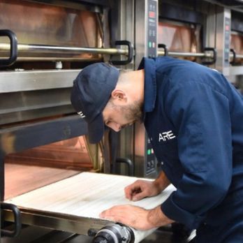 Alex's Restaurant Equipment - Professional technician in a navy ARE jumpsuit inspecting a high-volume industrial conveyor pizza oven for repair and mainten... - Restaurant Supplies Near Me - Anaheim, California Alex's Restaurant Equipment - Professional technician in a navy ARE jumpsuit inspecting a high-volume industrial conveyor pizza oven for repair and mainten... - Restaurant Supplies Near Me - Anaheim, California