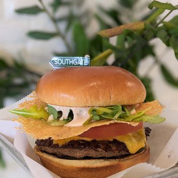 Burger Point - a hand holding a hamburger with a sticker on it - Burgers Near Me - South Gate, California Burger Point - a hand holding a hamburger with a sticker on it - Burgers Near Me - South Gate, California