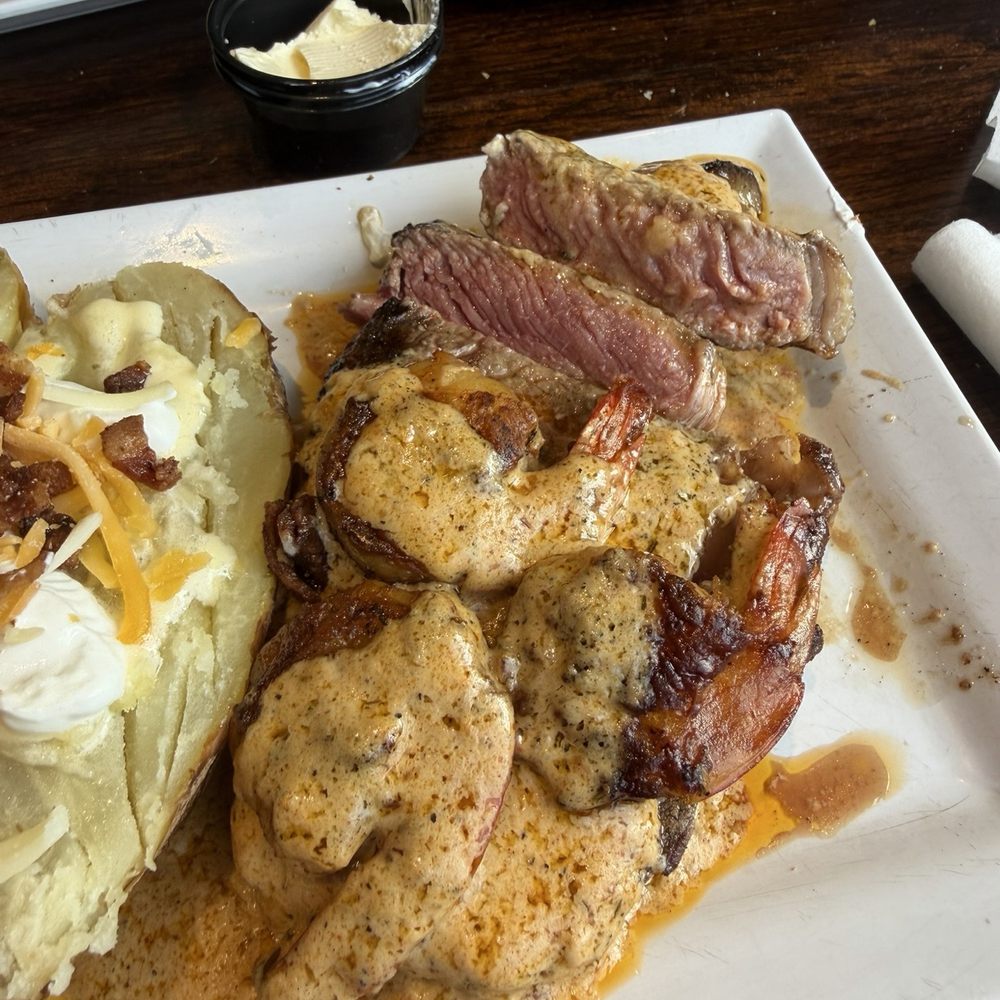 Back Porch Grill - Canun ribeye medium rare with grilled shrimp and loaded baked potato - Steakhouses Near Me - Hot Springs, Arkansas