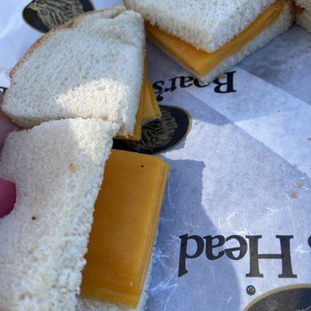 Herb's Market - a person holding a sandwich with cheese - Grocery Near Me - Montauk, New York