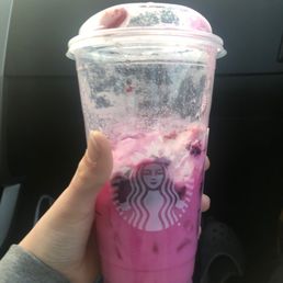 a hand holding a cup of pink drink a hand holding a cup of pink drink