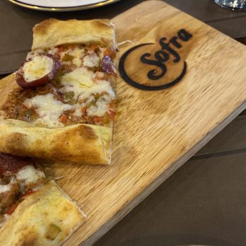Sofra Turkish Grill - a slice of pizza on a cutting board - Turkish Near Me - Waterbury, Connecticut