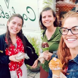 Three ladies holding an ice cream sandwich, a matcha cone with chocolate swirls and pitsachio crumbles, and a lavender ice cream cone. Three ladies holding an ice cream sandwich, a matcha cone with chocolate swirls and pitsachio crumbles, and a lavender ice cream cone.