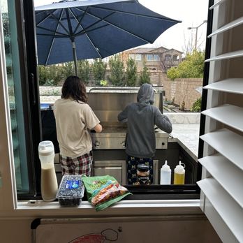 Quality Improvement Products - Kids at the outdoor kitchen griddle making breakfast, with screen open. You can't do this with a regular old screen!!! - Awnings Near Me - Corona, California