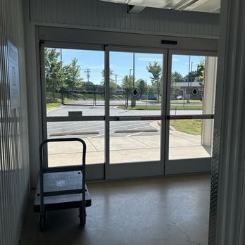 Prime Storage - Inside view of sliding glass doors for customer access to storage units with equipment provided to help ease your move. - Self Storage Near Me - Winston-Salem, North Carolina