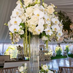 Lopez's Events and Rentals - Tall fresh floral centerpieces with tall clear vases.