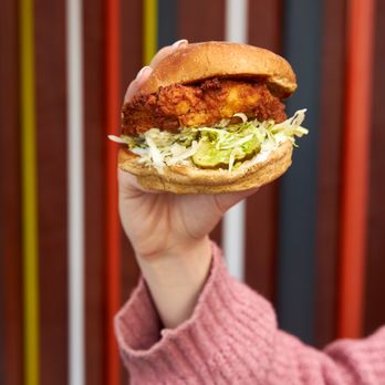 Burger Lounge - a hand holding a fried chicken sandwich - Burgers Near Me - Beverly Hills, California Burger Lounge - a hand holding a fried chicken sandwich - Burgers Near Me - Beverly Hills, California