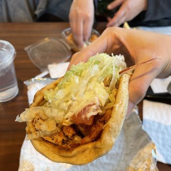 Greek Express Clintonville - a hand holding a sandwich - Greek Near Me - Columbus, Ohio Greek Express Clintonville - a hand holding a sandwich - Greek Near Me - Columbus, Ohio