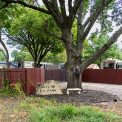 Skyline RV Park - Welcome to Skyline RV Park, where mature shade trees and wooden fencing frame the entrance to our RV community.