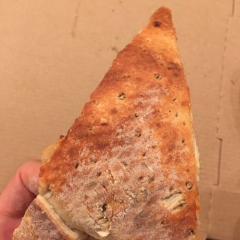 Tomacelli's Pizza & Pasta - a hand holding a piece of pizza - Pizza Near Me - Sioux Falls, South Dakota