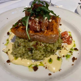 Montrio - Delicious salmon over pesto risotto with Mornay Sauce, topped with heirloom tomato and feta cheese - New American Near Me - Monterey, California Montrio - Delicious salmon over pesto risotto with Mornay Sauce, topped with heirloom tomato and feta cheese - New American Near Me - Monterey, California
