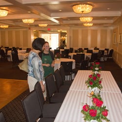 Lilium Florist - Lilum florist Sari, putting centerpieces out for wedding reception.  Red roses in teapots.
