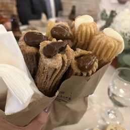 a person holding a bag of churros a person holding a bag of churros