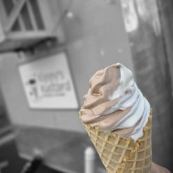 Kippy's Kustard - Close-up of the Vanilla Chocolate Twist Frozen Custard inside a large Waffle Cone, with the side of the trailer in the background.