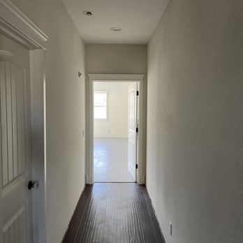 Wall and Ceiling Pros - a hallway leading to a door - General Contractors Near Me Wall and Ceiling Pros - a hallway leading to a door - General Contractors Near Me