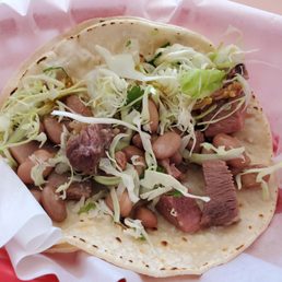Photo of Tacos Moreno - Santa Cruz, CA, United States. Partially eaten... So you can see what's in it. Lengua taco. Cabbage, pinto beans, cilantro, onion, but on lengua no tomato unless you ask!
