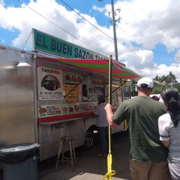 a man and a woman standing in front of a food truck a man and a woman standing in front of a food truck