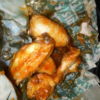 Wingstop - a basket of chicken wings with sauce - Chicken Wings Near Me - Frederick, Maryland