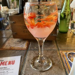 a glass of water with oranges in it