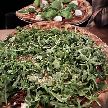 Coalfire - Roasted tomato & arugula pizza in the front, and a meat one on special in the back - Pizza Near Me - Chicago, Illinois