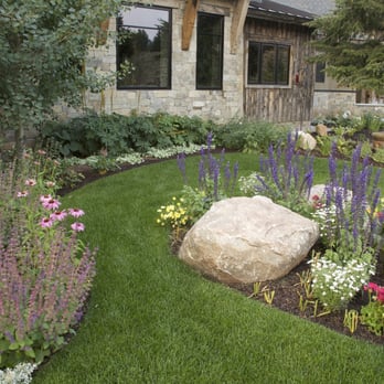 Village Gardener - a large rock in the middle of a flower garden - Gardeners Near Me - Jackson, Wyoming