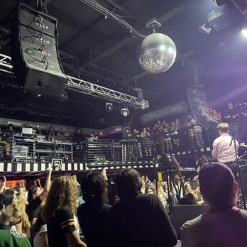 Parish - Another view of the floor and soundboard - Crowd gathered in a music venue with a stage, musicians, and a disco ball overhead, with audience members on the main floor and balcony. - Music Venues Near Me - Austin, Texas