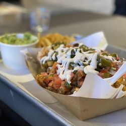 Nacho Bizness - Asada Fries Hella Sized with chips and guacamole.