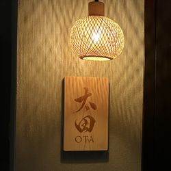 Ota - The lantern and sign in the small, hidden waiting room. A door that leads to the omakase counter is next to the sign.  Very cool touch.