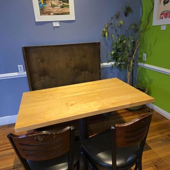 Little Green Hive - A seating area for four surrounded by colorful walls with artworks from a local artist. - Coffee & Tea Near Me - Roanoke, Virginia