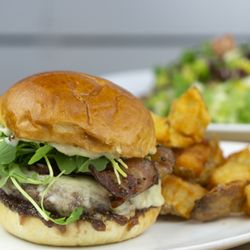 Taste Community Restaurant - Bacon Jam Burger | 
All-beef patty topped with aged white cheddar, arugula, tangy bacon-onion jam, mustard, and aioli on a toasted brioche.