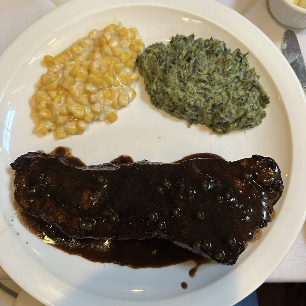 NY Steak smothered in sauce with creamed corn and creamed spinach. NY Steak smothered in sauce with creamed corn and creamed spinach.