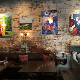 a brick wall with paintings on it a brick wall with paintings on it