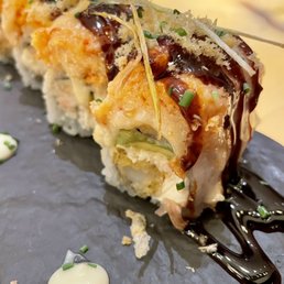 Baked Lobster Roll - Shrimp tempura, cucumber avocado, spicy lobster, tempura crunch and garlic yum yum sauce.