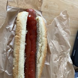 Foot long all beef hotdog with a little ketchup.