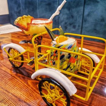 Grand Hacienda - a yellow toy car with a basket of bananas in the back - Mexican Near Me - Clearwater, Florida