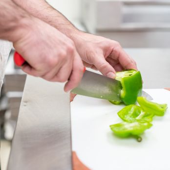 Chubby's Pizza - a man chopping peppers on a cutting board - Pizza Near Me - Charleston, Illinois